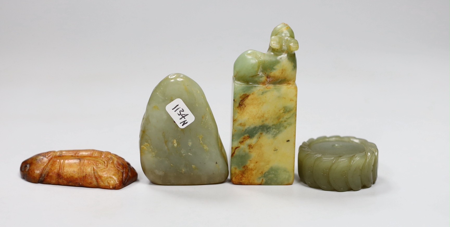 A Chinese green jade 'cash' wheel and a russet jade cicada, a jade pebble carving and a hardstone seal